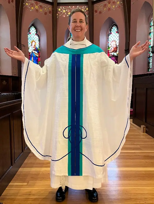 The chasuble echoes the scrolls and colors from the paraments