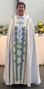 white cope with blue and green floral embroidery