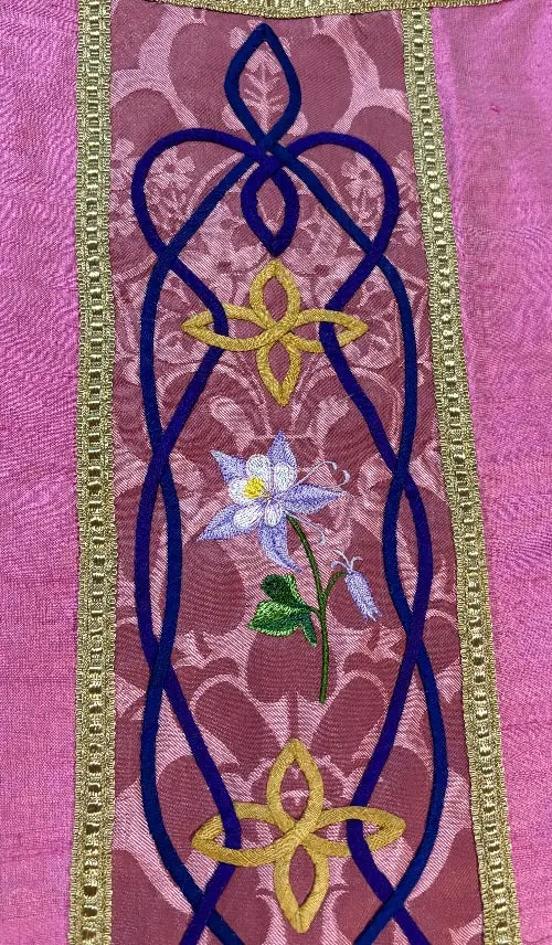 purple clergy vestment detail with floral embroidery and geometric design