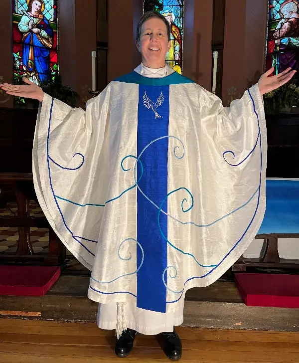 white chasuble with blue panel and scroll embroidery