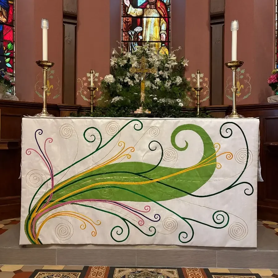 The altar with Easter vestments at Quincy, surrounded by flowers and church architectural details