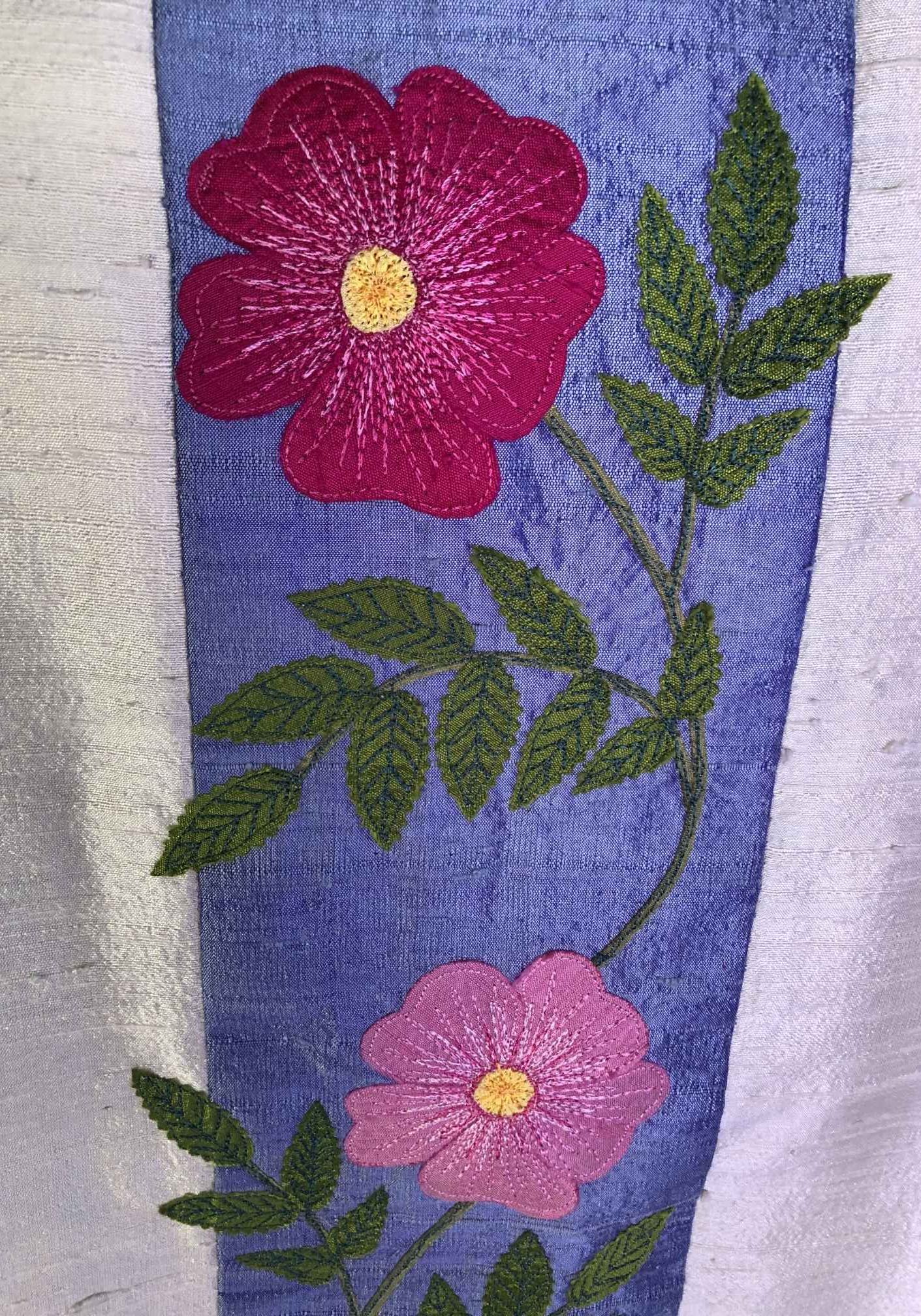 Applique and thread painting detail of the beach roses on the chasuble