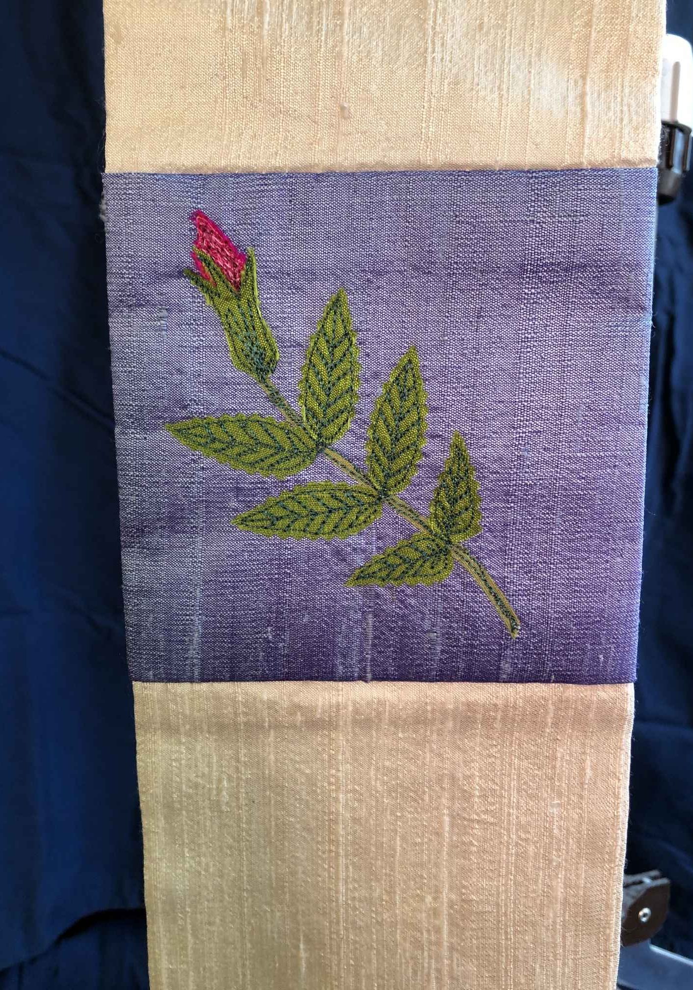 Detail of the dupioni silk with ocean blue background and thread-painted beach rose